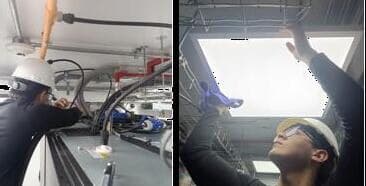 Técnicos con casco limpiando bandejas de cableado y luminarias del techo